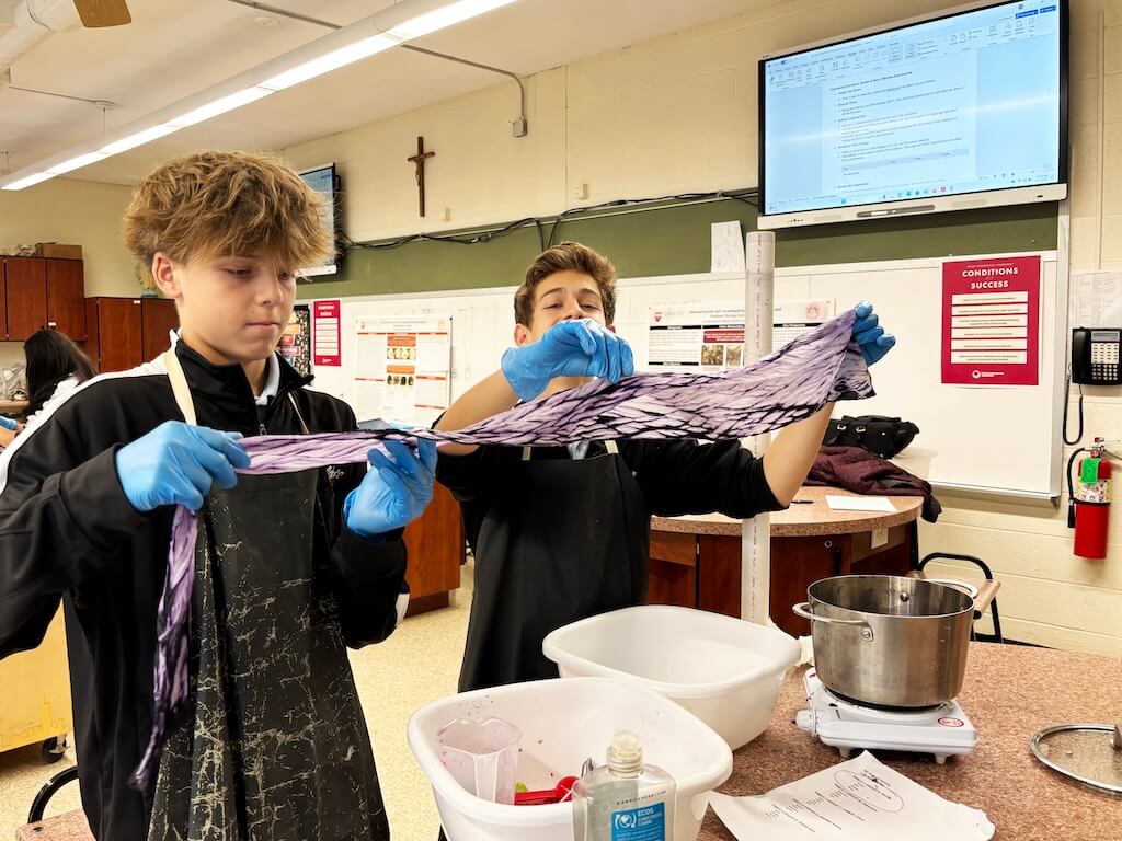 2 boys tie dye fabric in class